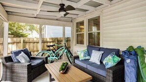 A covered porch with wicker furniture, a ceiling fan, and bicycles. - Charming Park Circle Bungalow with Screened Porch (North Charleston)