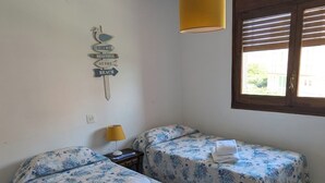 A room with two beds, a lamp, a wall decoration, and a window with blinds. - Incredible view right on the beach! (Miami Playa)