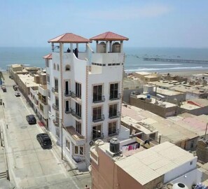Stunning coastal views from this multi-story building's central tower, featuring balconies and a flat roof.