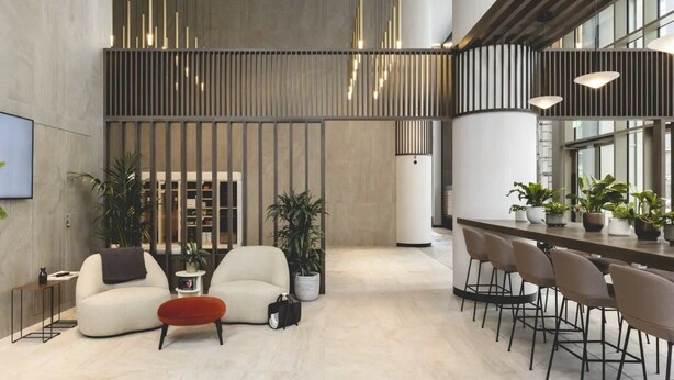 A modern interior with a seating area, a bar, and a kitchen. - Urban Rest Stratford (London)
