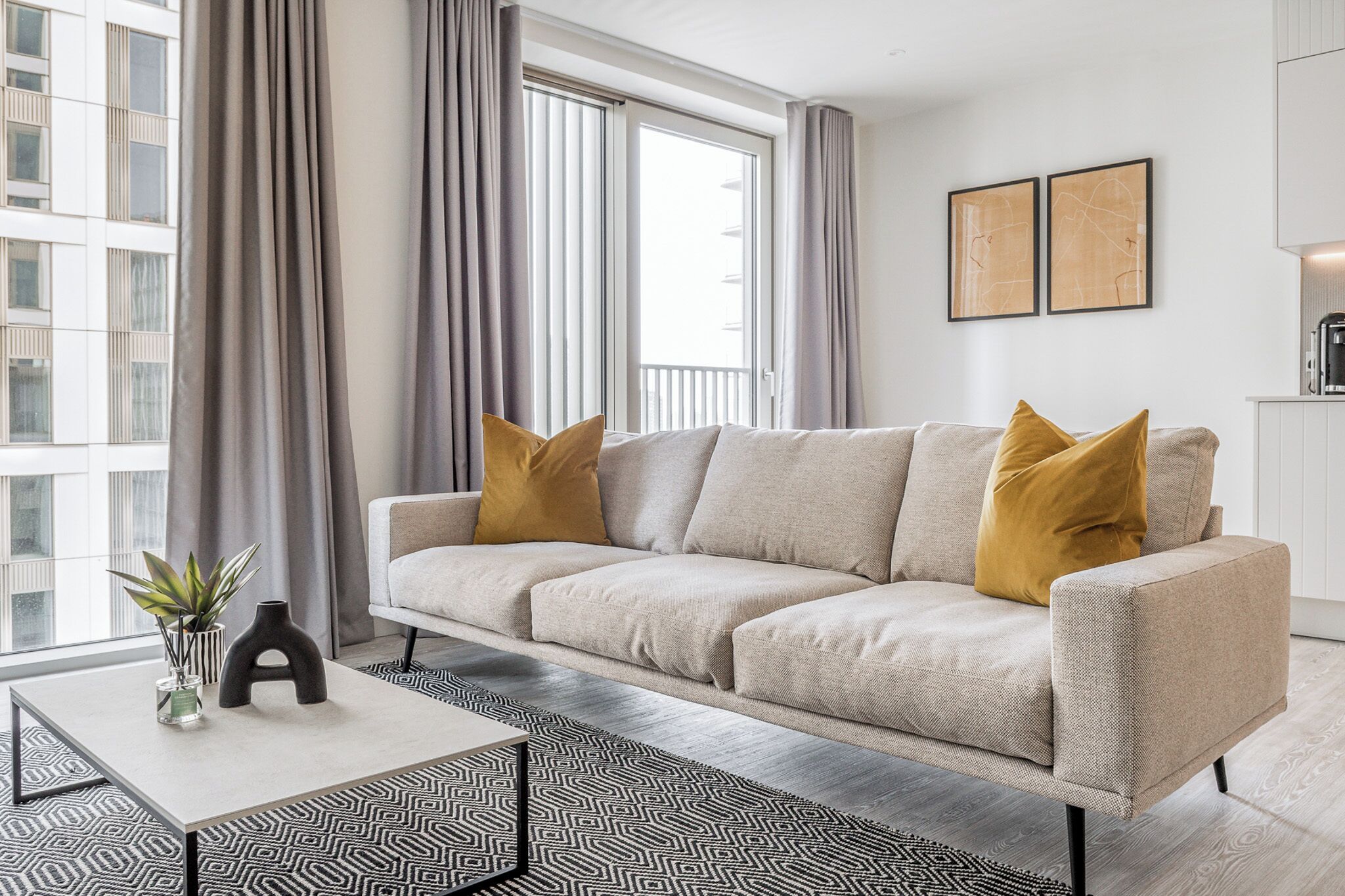 Een moderne woonkamer met een bank, een salontafel en een kamerkleed met een patroon.