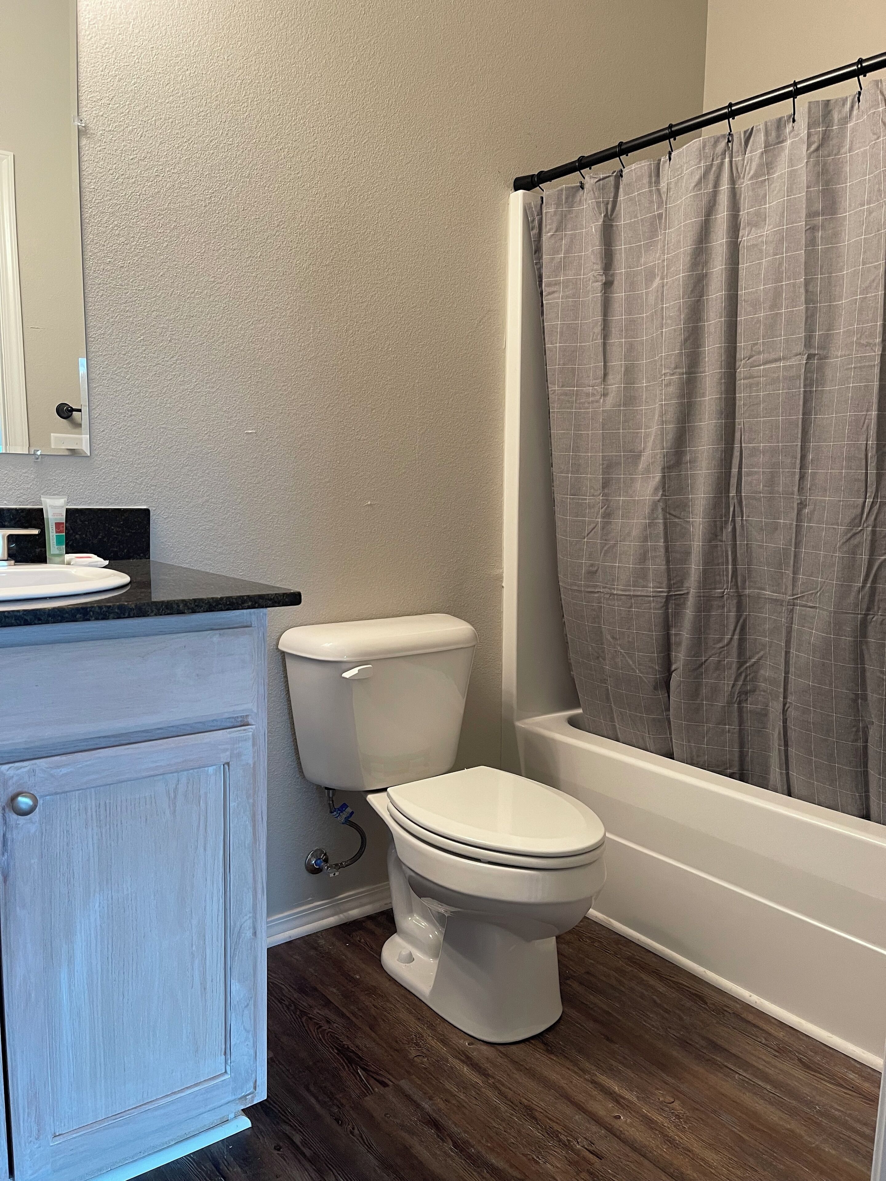 Une salle de bain avec des toilettes, un lavabo et une baignoire.