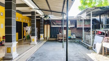 A covered outdoor area with a yellow wall, a sign for 'Spache Black Gold', and a brick wall in the background.