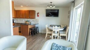 A compact living space with a kitchenette, dining area, and seating.
