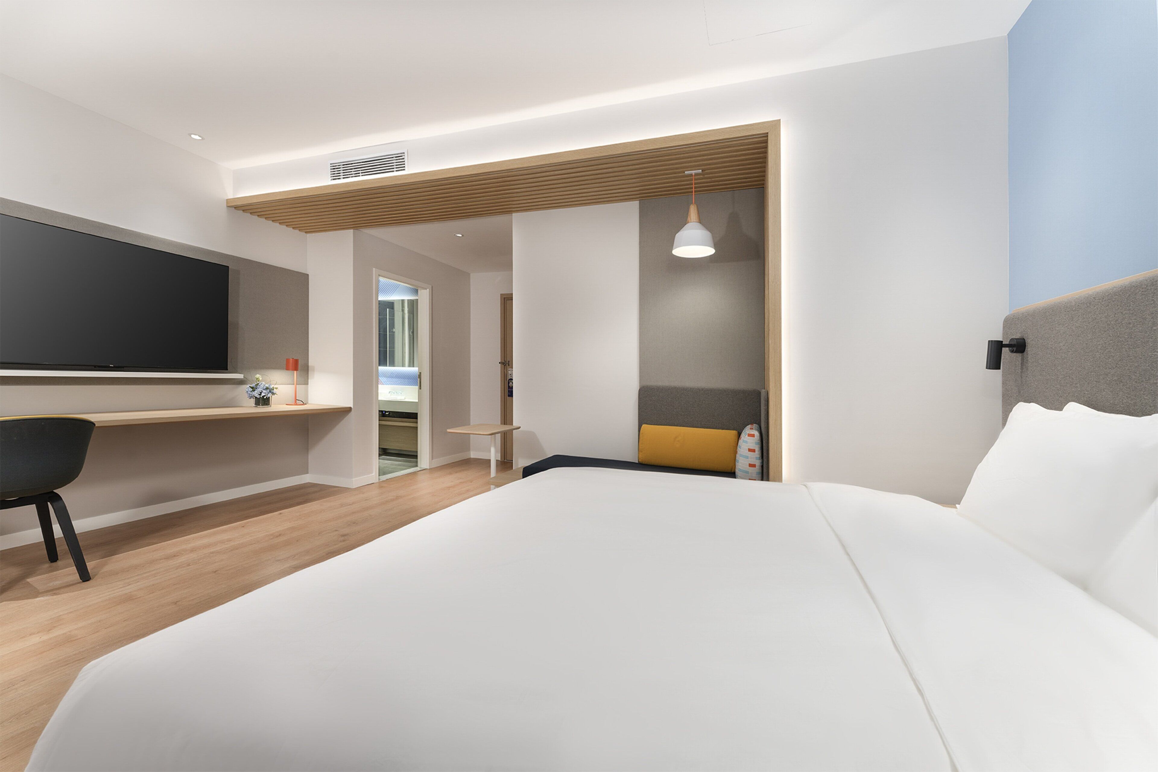Een moderne hotelkamer met een groot bed, een bureau en een zithoek.
