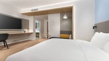 Een moderne hotelkamer met een groot bed, een bureau en een zithoek.