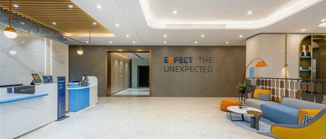 A modern reception area with a reception desk, seating area, and a wall with the text "EXPECT THE UNEXPECTED".