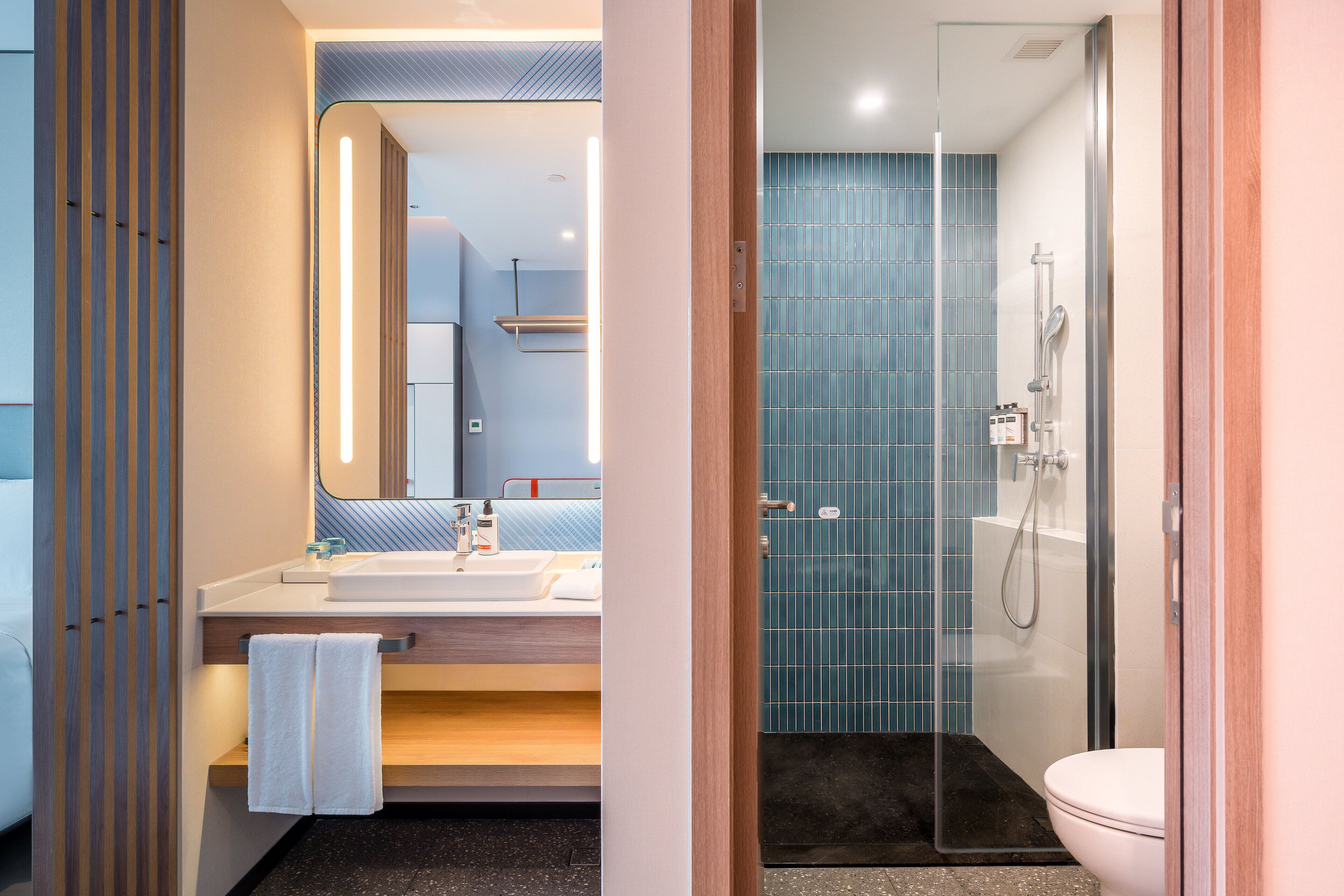 A modern bathroom with a shower, toilet, and sink.
