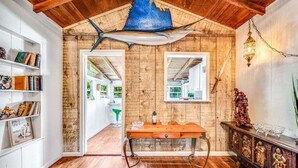 Ein Holzinnenraum mit Holzboden, einem Tisch und einem Bücherregal.