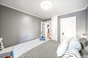 Um quarto com uma cama, uma escrivaninha e um guarda-roupa.