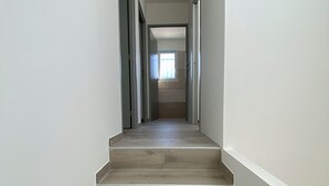 A narrow, wooden staircase leading to a landing with a window. - Villa Climatisée Proche Centre (Uzès)