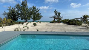 A swimming pool with a view of the beach and ocean. - BRAND NEW Beachfront Villa best sandy beach in TCI with pool Fox Tail Palm Villa (Whitby)