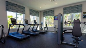 A gym with treadmills, a rowing machine, and a weight bench. - Outstanding 5BDR Disney Vacation (Kissimmee)