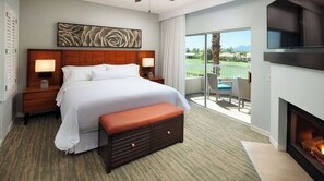 Relax in this stylish room with a large bed, flat-screen TV, and fireplace, offering a balcony with golf course and mountain views.