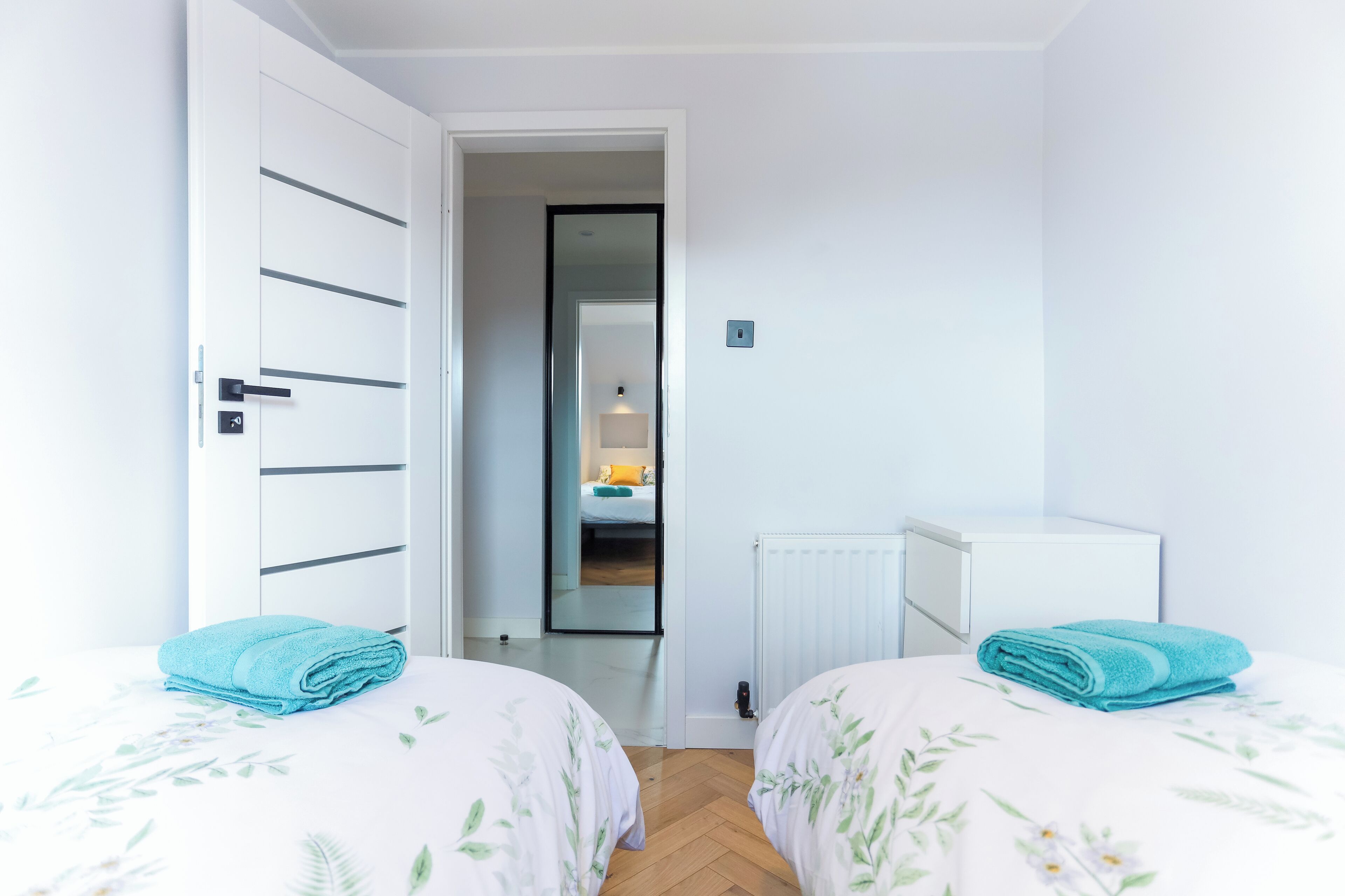 Un dormitorio con dos camas, un armario y un radiador.