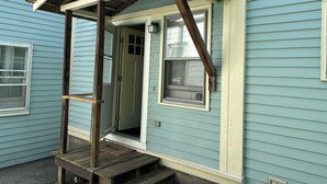 A wooden porch with a door leading to a room. - Traveler’s Den in Medford (Medford)