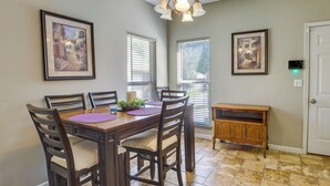 A dining area with a wooden table, four chairs, two framed pictures on the wall, and a small wooden cabinet. - Birmingham Home w/ Yard - 15 Mi to Downtown! (Birmingham)