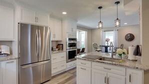 A modern kitchen with white cabinetry, stainless steel appliances, granite countertops, and pendant lighting. - Welcoming Willoughby Home: 1 Mi to Historic Dtwn (Willoughby)