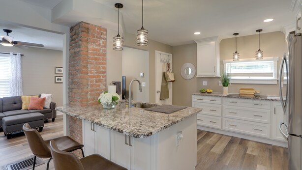A modern kitchen with a central island, white cabinetry, and pendant lighting. - Welcoming Willoughby Home: 1 Mi to Historic Dtwn (Willoughby)