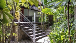 Un escalier menant à un bâtiment entouré d’une végétation tropicale luxuriante.