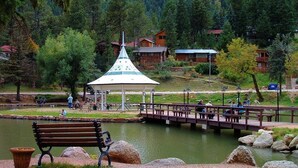 A park with a gazebo, benches, a bridge, and a pond.