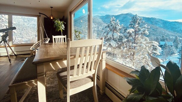 A dining area with a view of snow-covered mountains through large windows.
