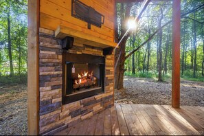 A wooden cabin with a stone fireplace, surrounded by a forest. - The "Bear with Me" Cabin is Perfect! (Broken Bow)