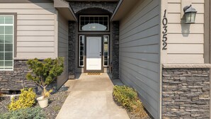 Une maison avec une façade en pierre, une porte d’entrée et une boîte aux lettres.