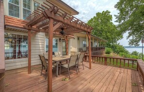Enjoy a serene outdoor seating area with a table and chairs under a pergola, surrounded by a scenic view.
