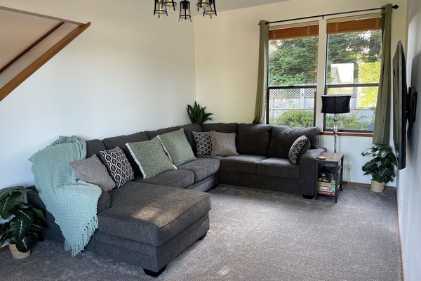 Living room #1 with an over sized sectional couch and a smart tv.
