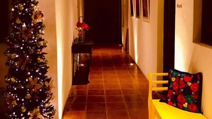 A narrow hallway with a brick ceiling, a Christmas tree, and a bench with a colorful cushion. - Luna Maya Antigua Hotel (Antigua Guatemala)