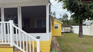 A yellow house with a porch, a wooden staircase, and a doormat with "HOME" written on it. - Off Duty Retreat ~Sleeps 10, Boat Slip, Screen Porch, Lots of Parking, 2 Grills (Steinhatchee)