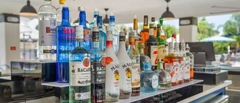 Un bar con varias botellas de alcohol, incluyendo Bacardi y Sky.