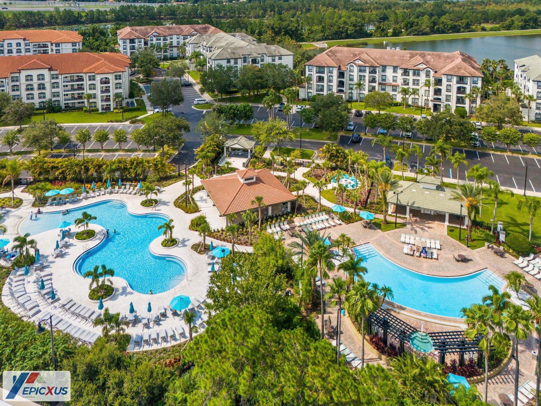 Ein Resort mit mehreren Gebäuden, einem großen zentralen Pool und umgebender Bepflanzung.