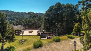 Un vaste espace extérieur doté d’une terrasse en bois, d’un chemin de pierre et d’une végétation luxuriante.