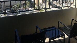 A balcony with a view of a cityscape, including various buildings and a clear sky.