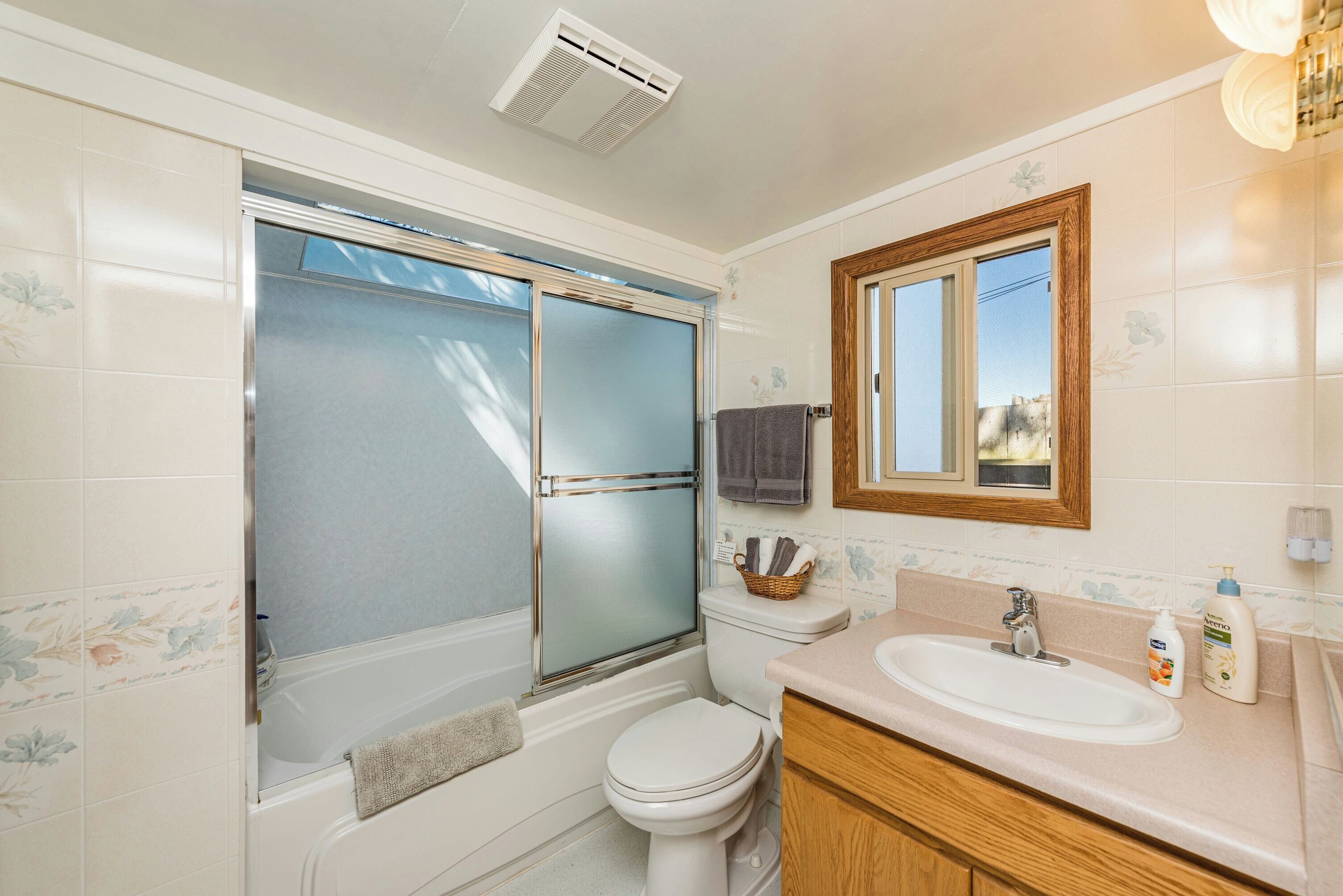 A bathroom with a bathtub, toilet, and sink.