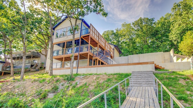Un immeuble à plusieurs étages doté d’une terrasse en bois qui mène à un escalier.