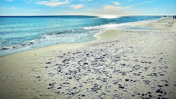 A beach with footprints in the sand, a clear sky, and the sun shining. - 5 STARS Beachfront Condo, Indoor/Outdoor Pools, Hot Tub & Tennis! BOOK NOW! (Orange Beach)