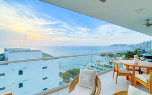 Un balcon avec vue sur la mer et les bâtiments.