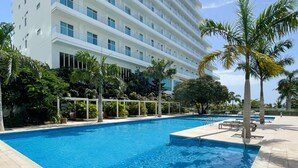 A swimming pool with a white building in the background.