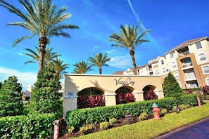 A hotel entrance with palm trees, a sign reading 'Vista Cay Resort,' and a fire hydrant.
