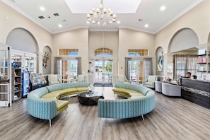 A spacious lobby with a curved seating area, a reception desk, and a view of the outdoors through large windows.