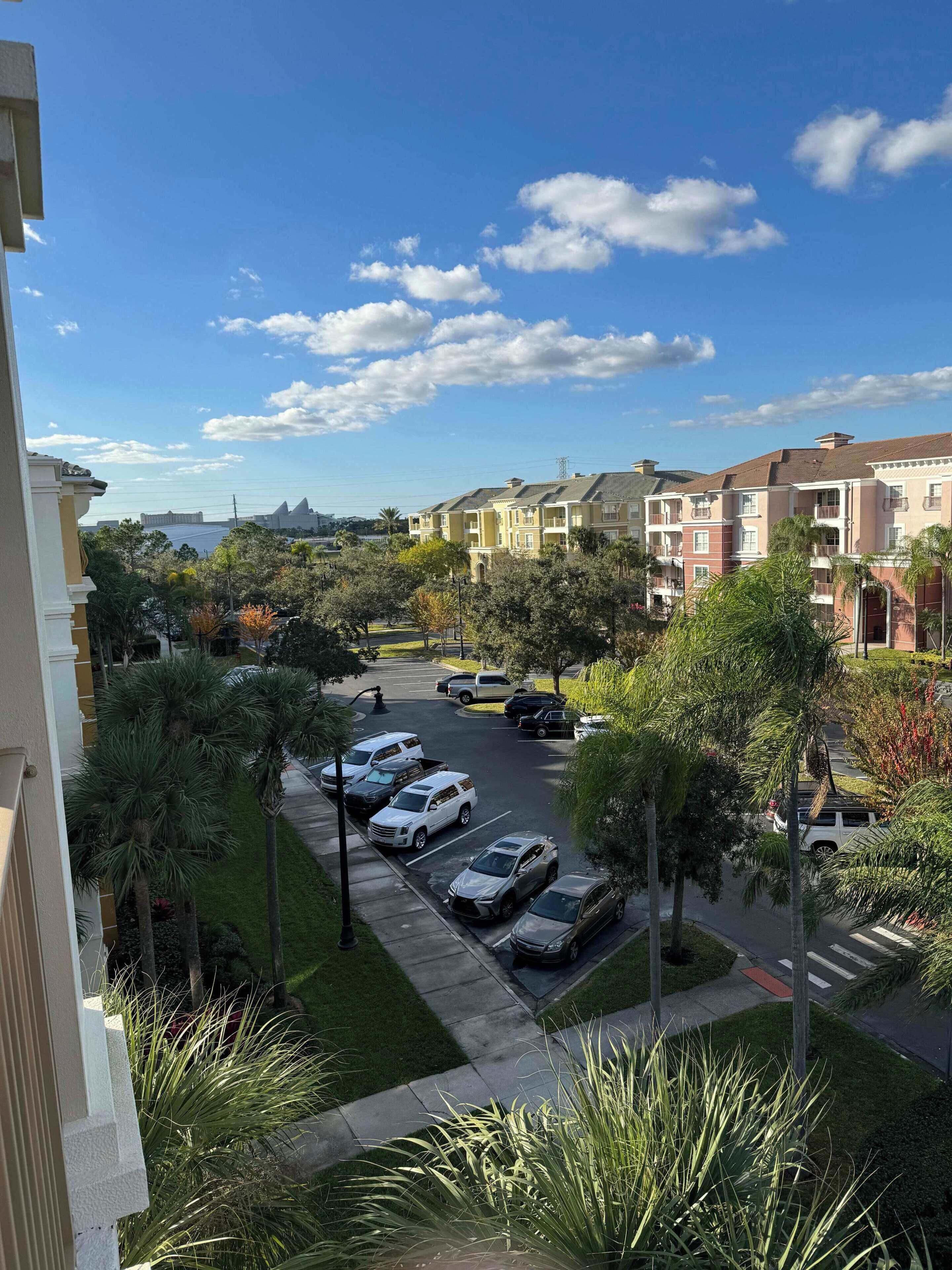 Zona residencial amb edificis d'altes plantes, un aparcament i un cel serè.