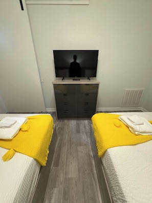A hotel room with two beds, a TV on a stand, a dresser, and a vent on the wall. - The Epic 24407 Penthouse Vista Cay Resort Orlando FL (Orlando)