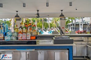 A bar area with various liquor bottles, a cash register, and a Tequila Patron sign.