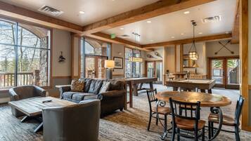 A spacious living area with a fireplace, a dining table, and comfortable seating.