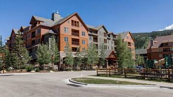 A multi-story hotel with a central courtyard, outdoor seating, and a playground.