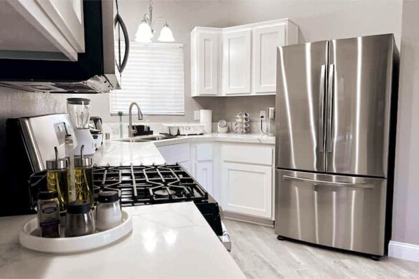Enjoy cooking in this well-equipped kitchen with a gas stove, refrigerator, and ample countertop space.