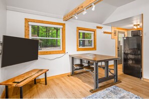 A compact kitchen with wooden accents, a dining table, and a built-in refrigerator. - Lakeview Deck | Sauna l Firepit | Fall | Near TC! (Traverse City)